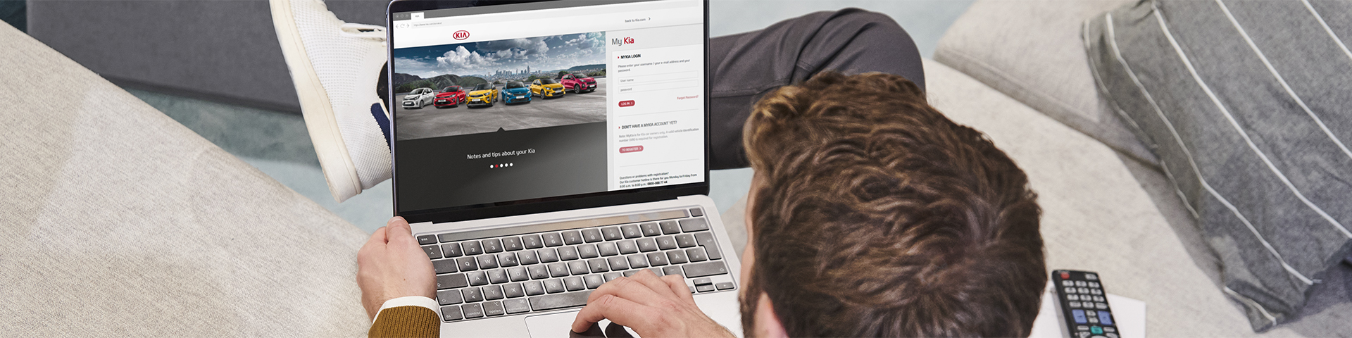 Man is holding a smartphone with the MyKia app